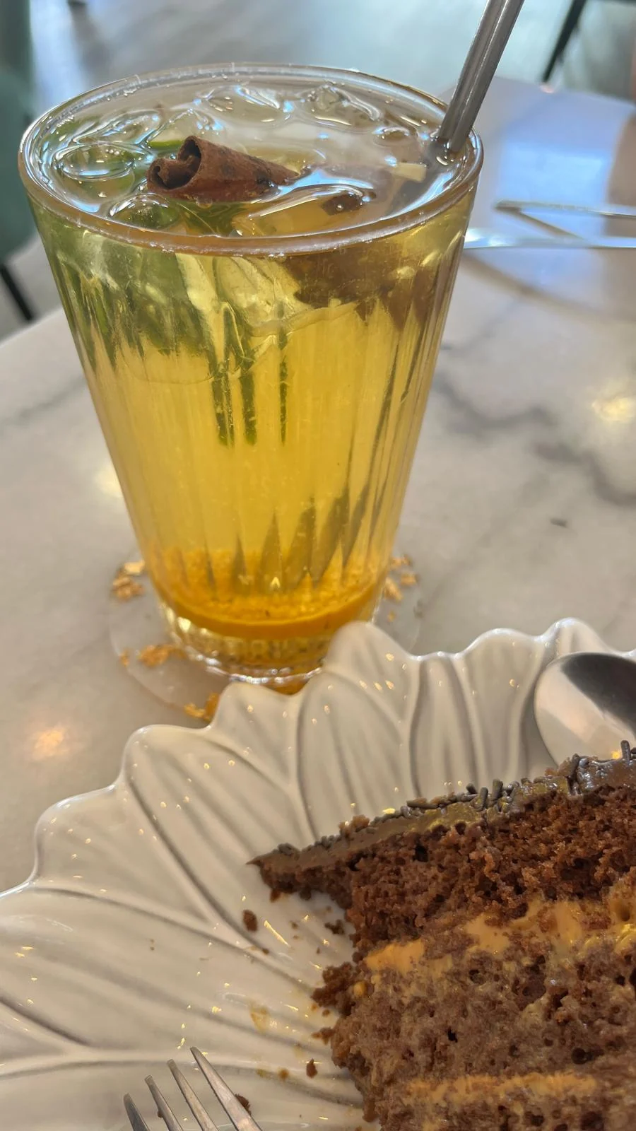 Chá gelado com hortelã, citrinos e canela ao lado de bolo brigadeiro com doce de leite