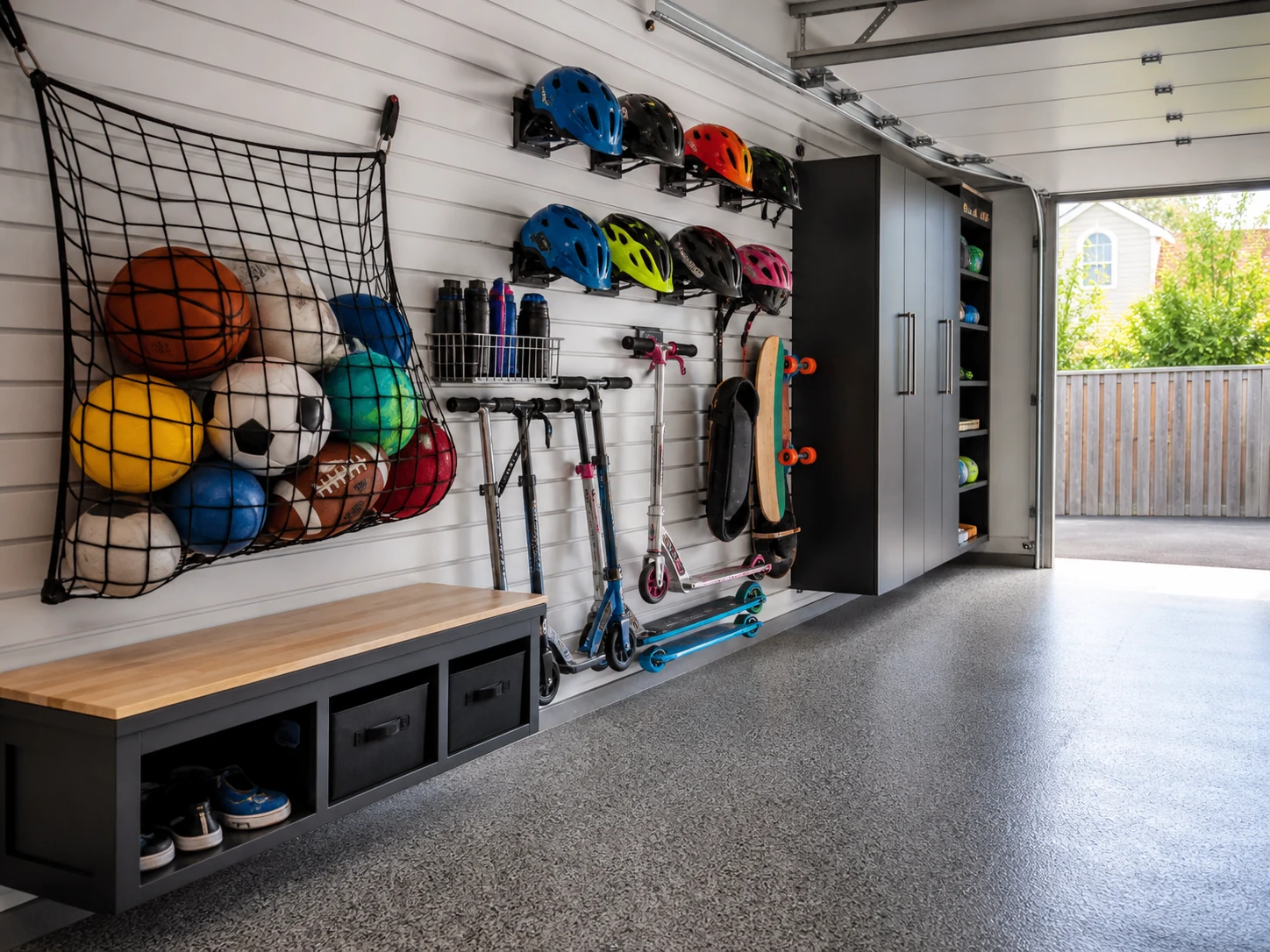 Zona da garagem organizada para bolas, capacetes e trotinetes